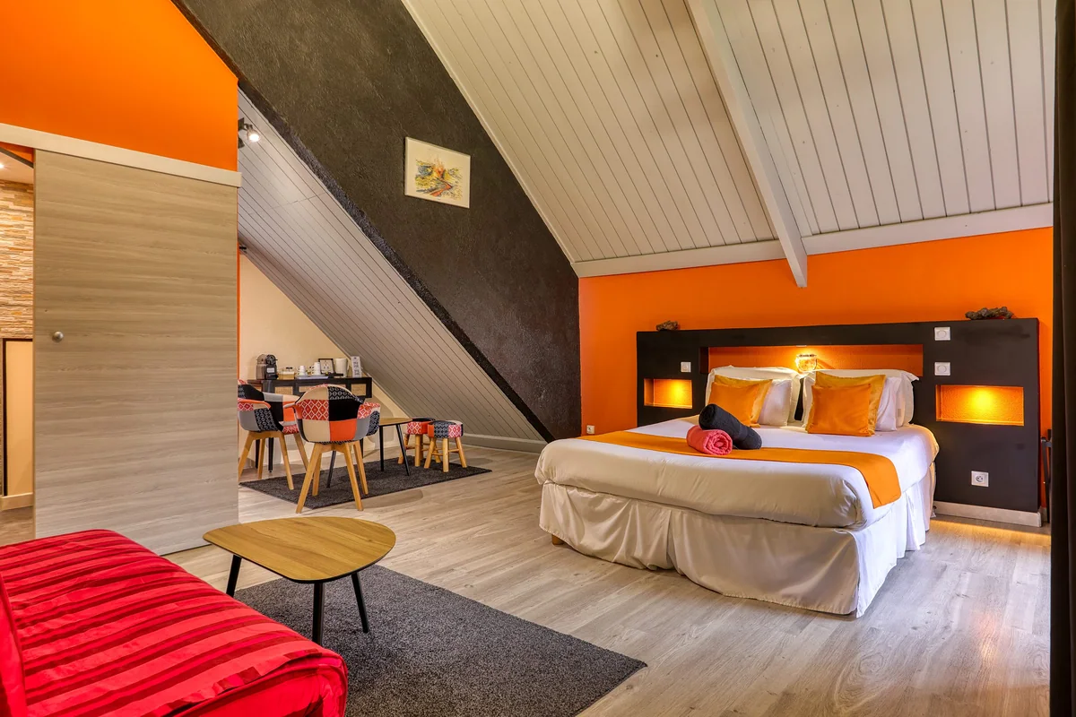 La chambre Fournaise, tête de lit orange et plafond blanc en pente