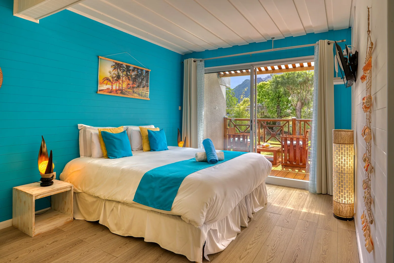 La chambre Plage, aux murs bleu azur, avec sa porte-fenêtre ouverte sur la terrasse