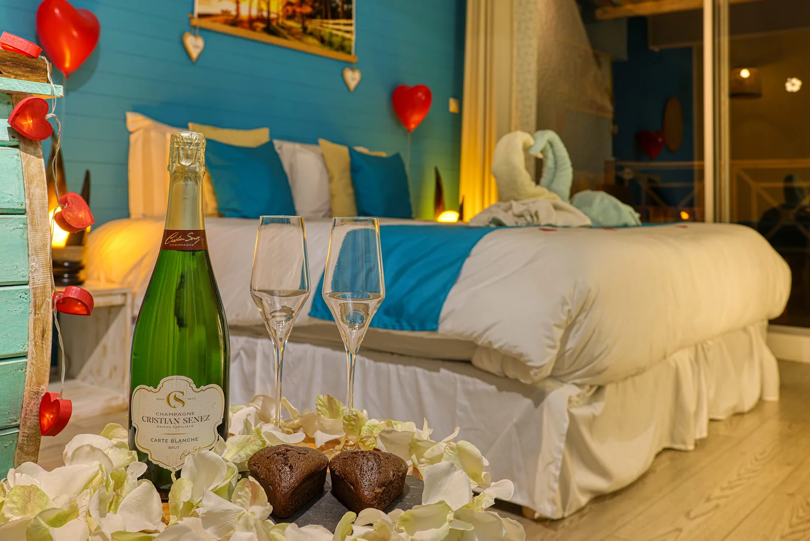 Une chambre préparée pour un séjour romantique, cœurs rouges et champagne