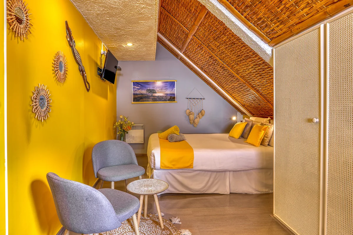 La chambre Savane, mur jaune soleil et plafond en bambou tressé